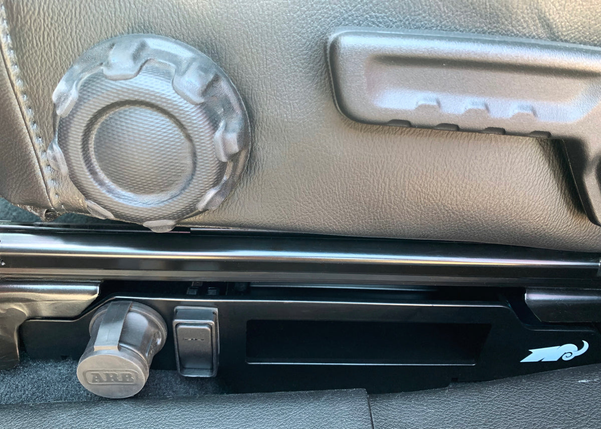 Close-up of a car's interior door panel with a speaker and handle.